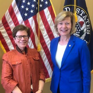 Chancellor Rebecca Blank and Sen. Tammy Baldwin in front of the American flag