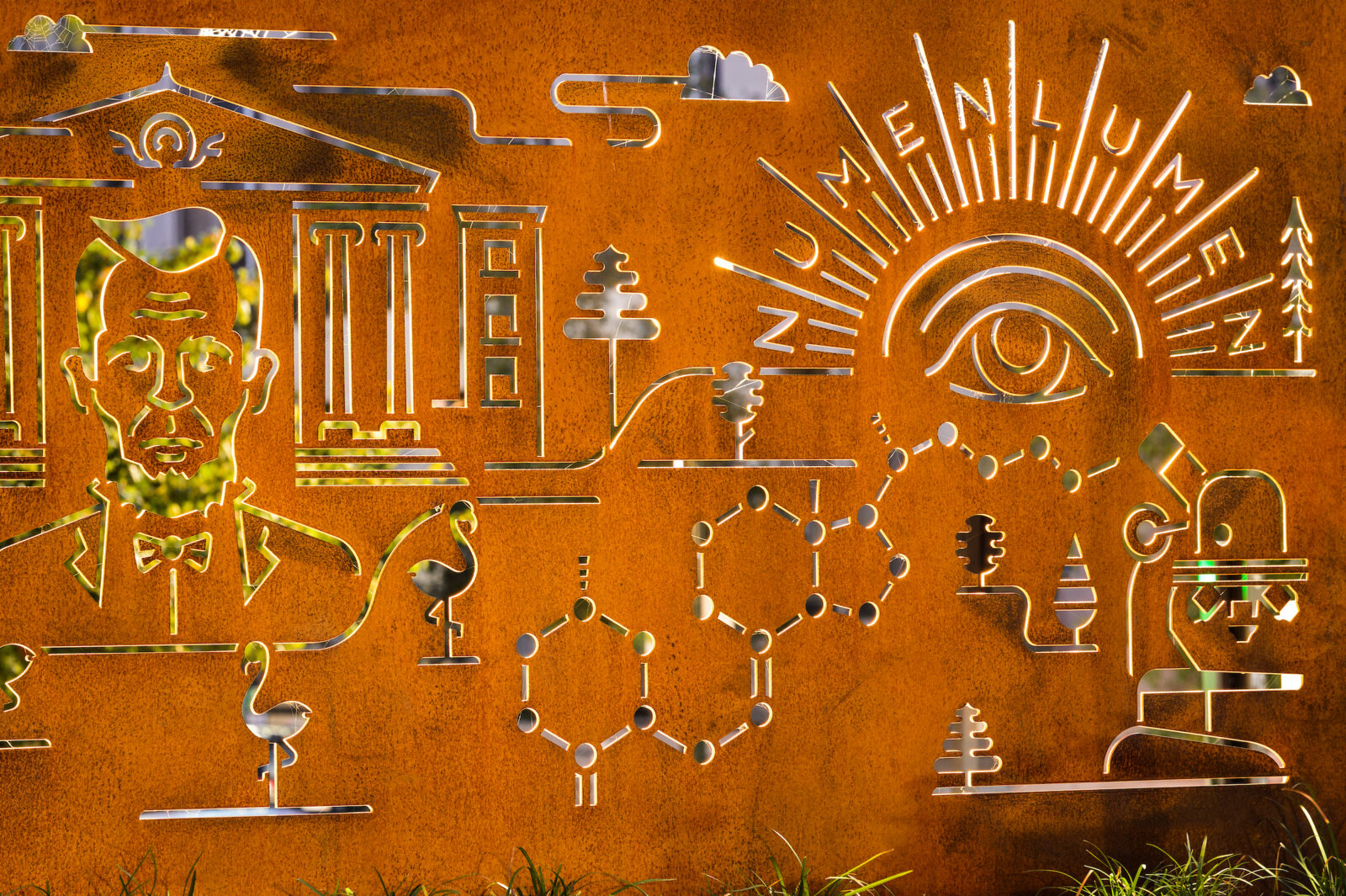 Cut into rusted steel, backlit and iconic graphics of the Badger Pride Wall include Bascom Hall, Abraham Lincoln, the Numen Lumen seal, and Vitamin D research.